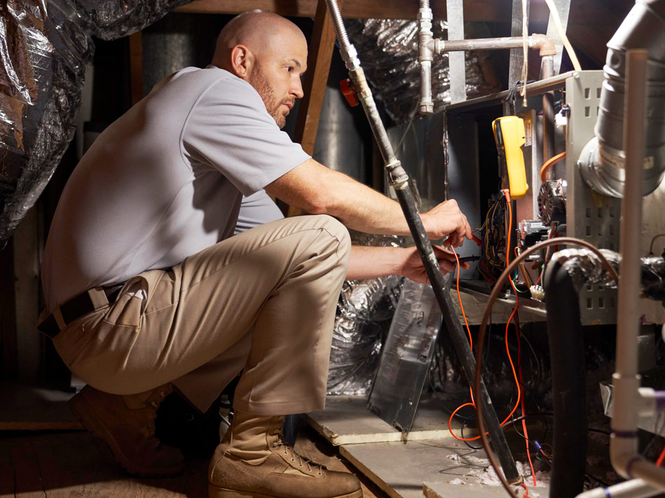 Residential-Maintenance-19LNX_0026_D_4408-950×712 Technician performing residential HVAC maintenance in attic